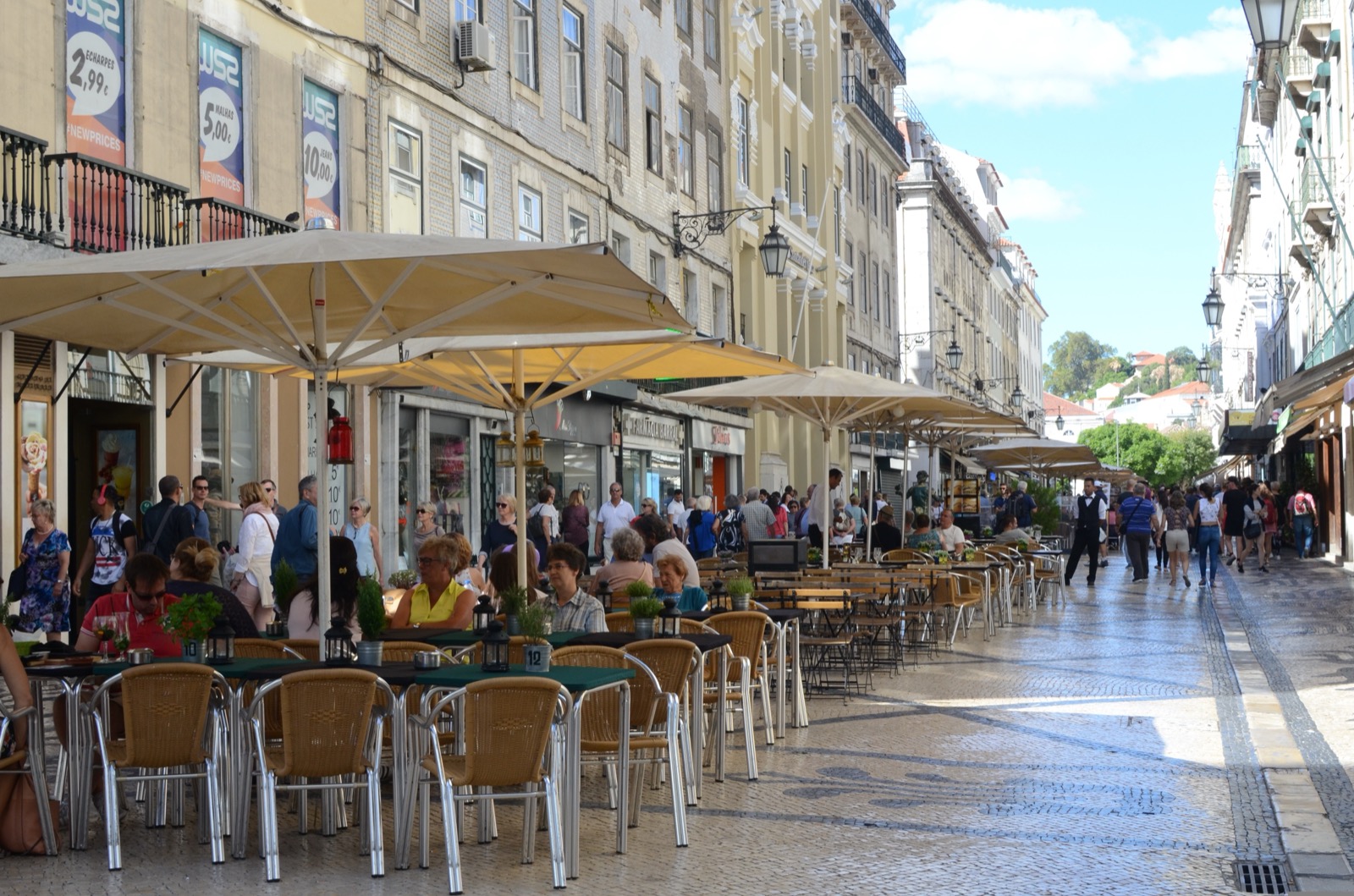 A tiled Portuguese street with outdoor cafe seating